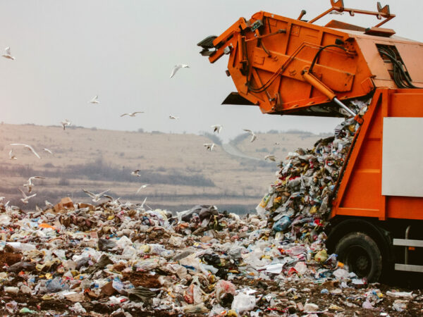Garbage truck dumping trash in landfill