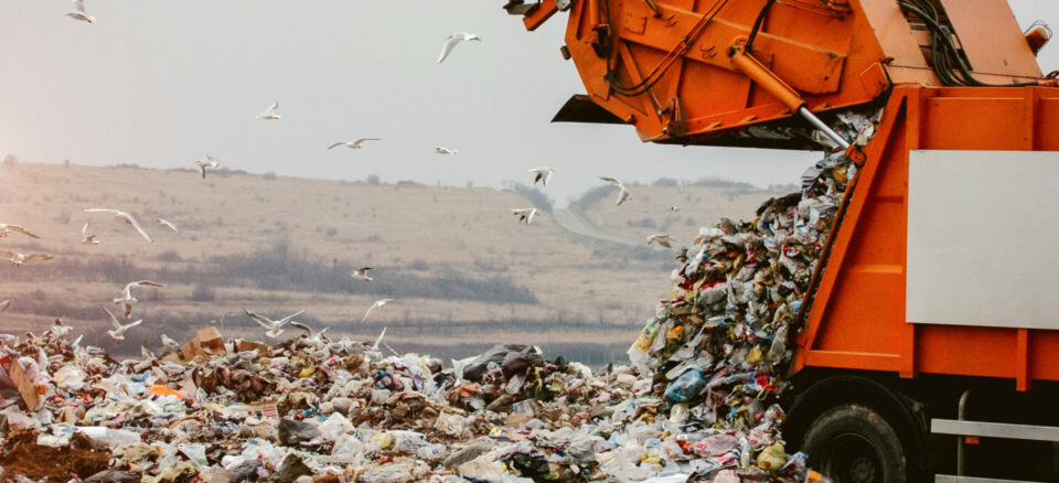 Garbage truck dumping trash in landfill