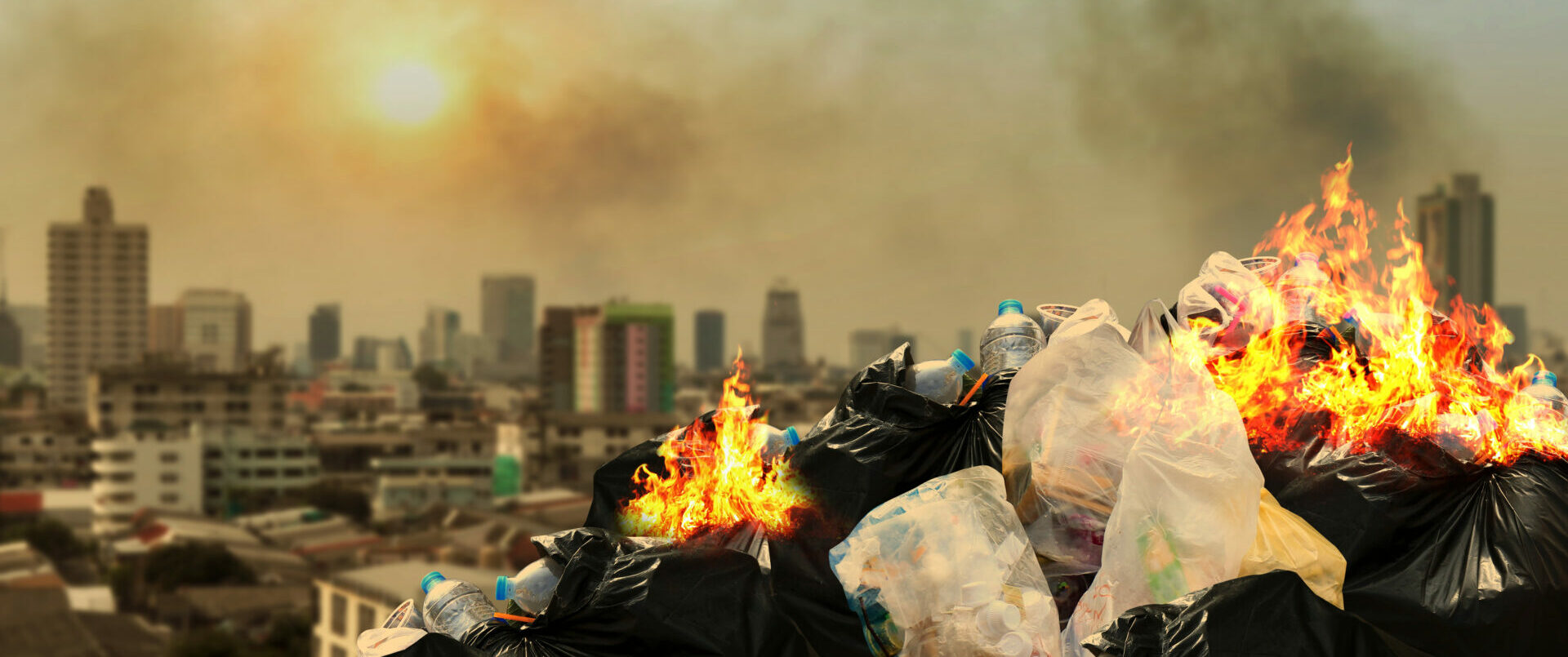 Garbage pile on fire with city in the background
