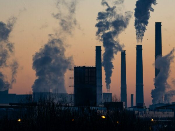 Photo of a incineration facility with several smokestacks spewing out emissions.