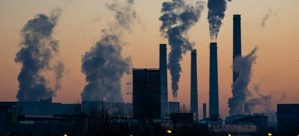 Photo of a incineration facility with several smokestacks spewing out emissions.