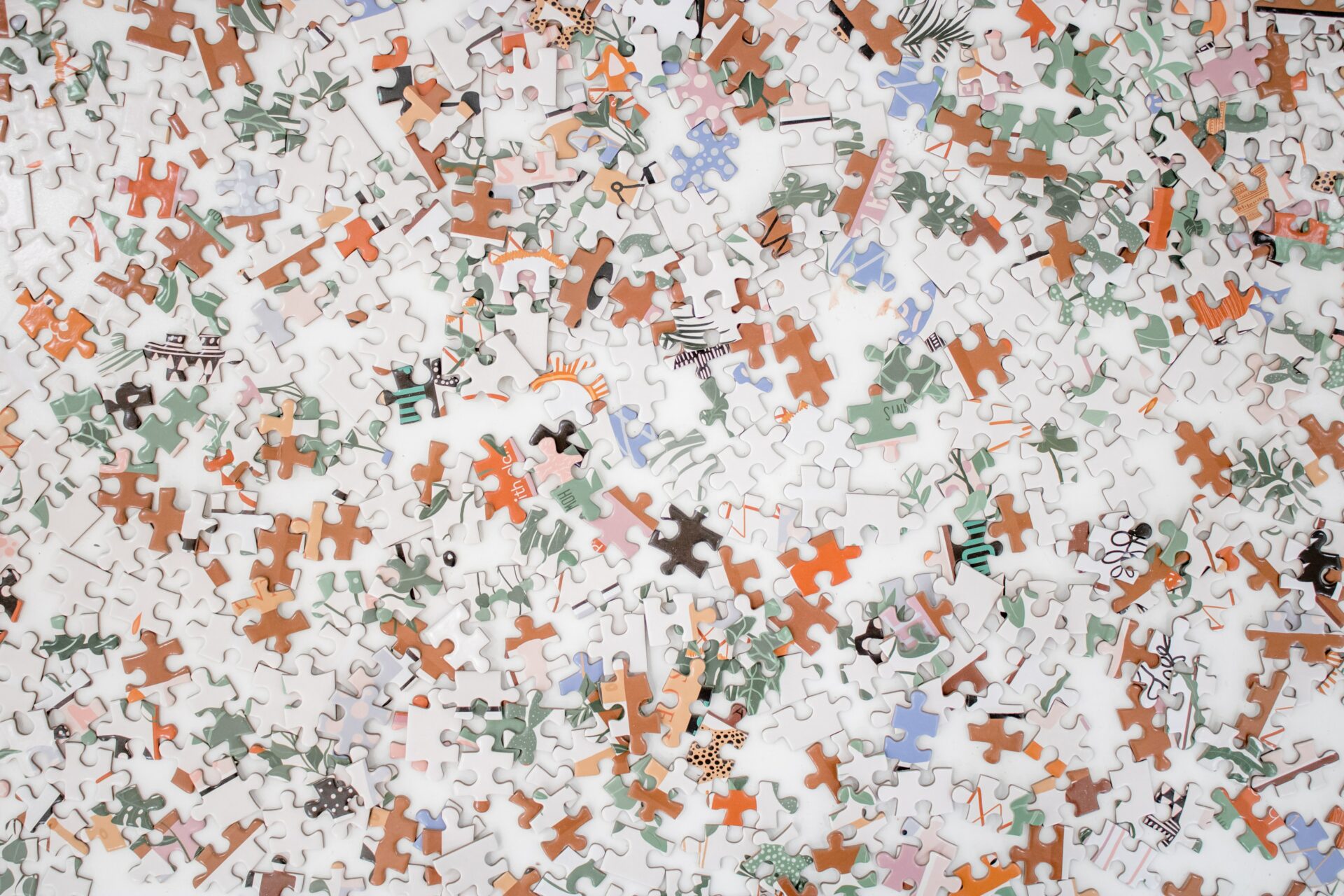 White, orange, light blue, sage green, pink, and tan puzzle pieces