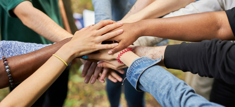 Close-up photo of diverse people's hands gathered together