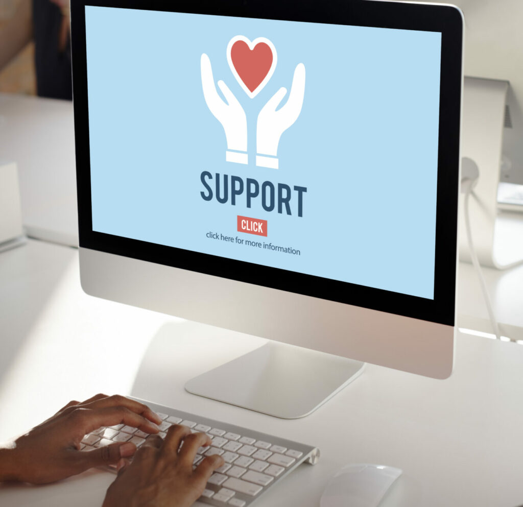 Computer screen with blue background and word "support" under illustrated hands holding a heart.