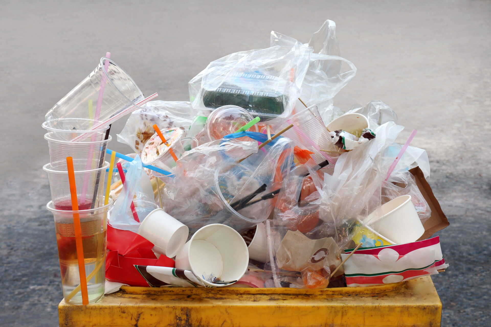 pile of plastic waste in yellow trash bin