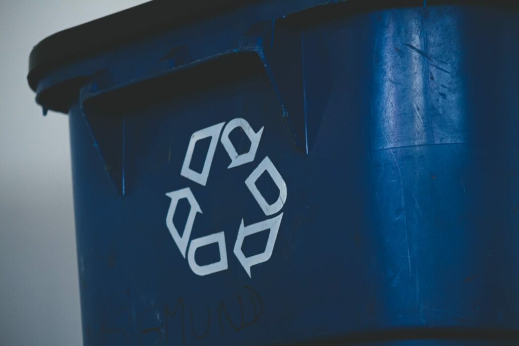 Blue recycling bin with recycling symbol on it