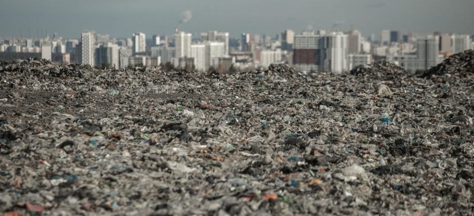 landfill in focus with city line out of focus in the back highlights environmental injustice