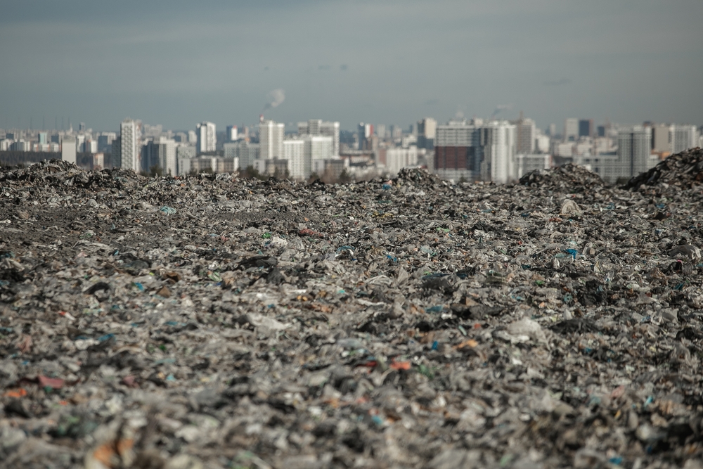 landfill in focus with city line out of focus in the back highlights environmental injustice