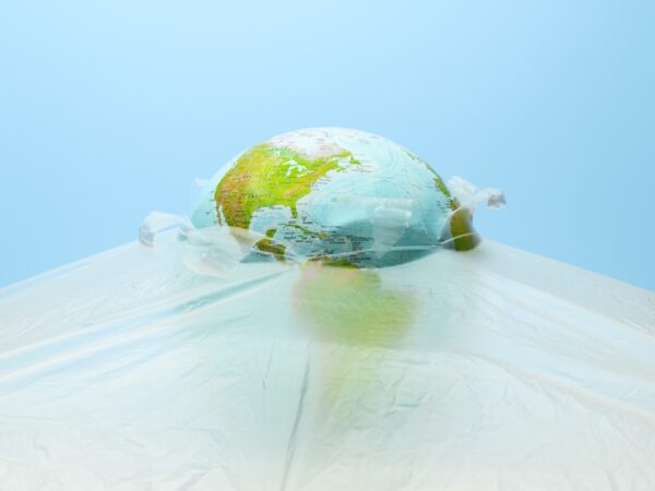Globe breaking out of plastic film.