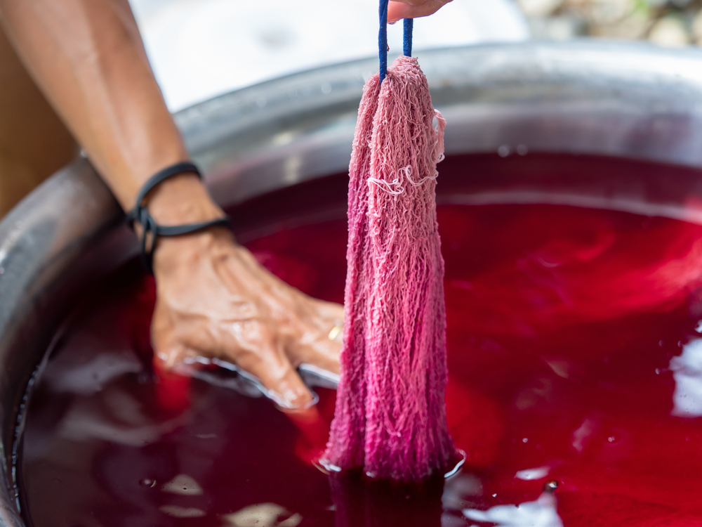 Natural or synthetic fibers in the process of being dyed red.