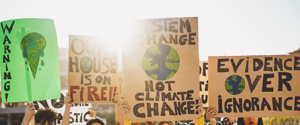 Group of demonstrators at climate rally holding up signs.