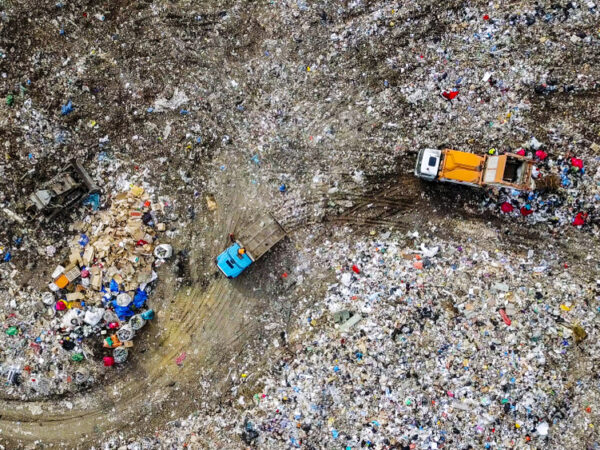 Aerial view of garbage trucks unloading trash in a landfill