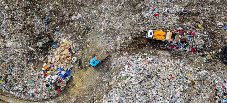 Aerial view of garbage trucks unloading trash in a landfill