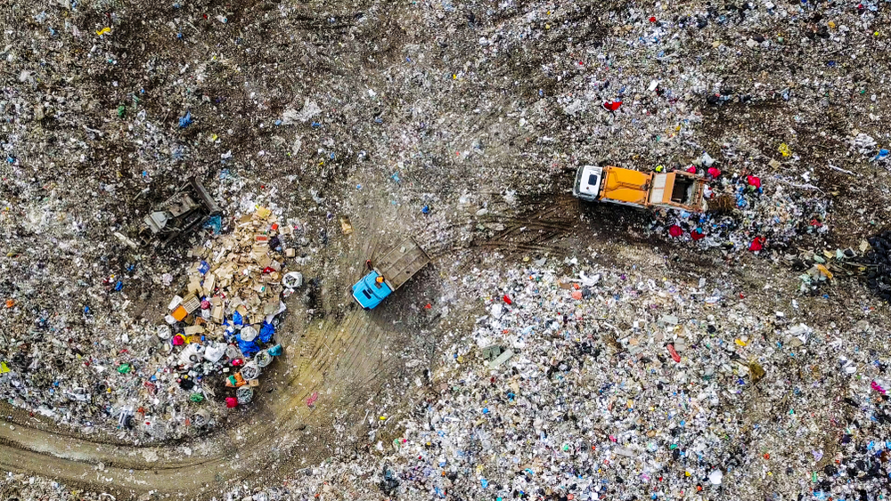 Aerial view of garbage trucks unloading trash in a landfill