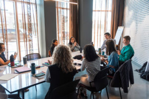 Just Zero staff member sitting inside around a conference table