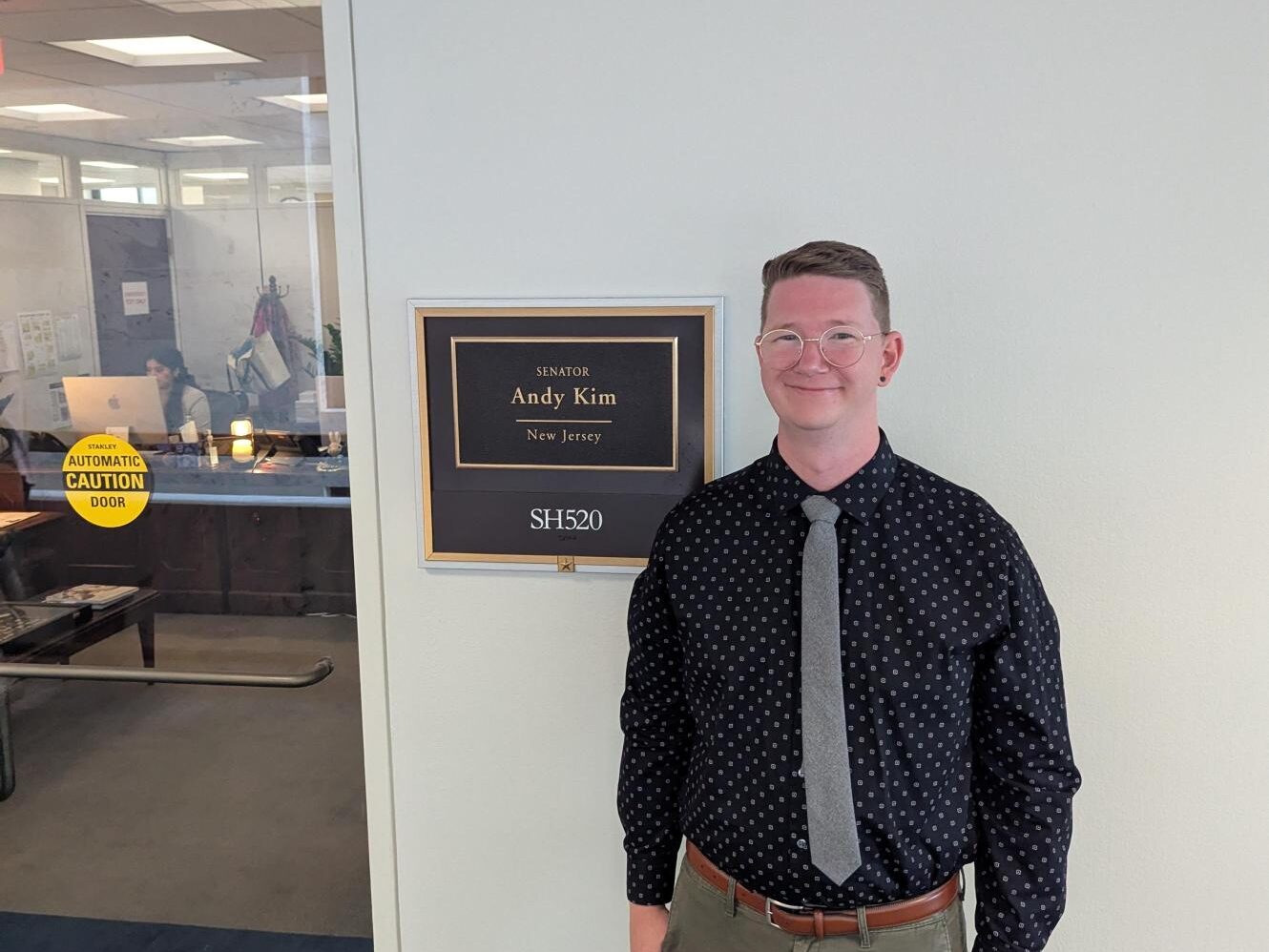 Man standing outside a legislator's office.