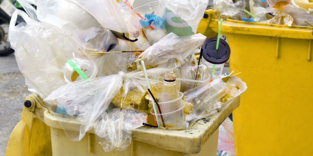 garbage bins overflowing with plastic packaging